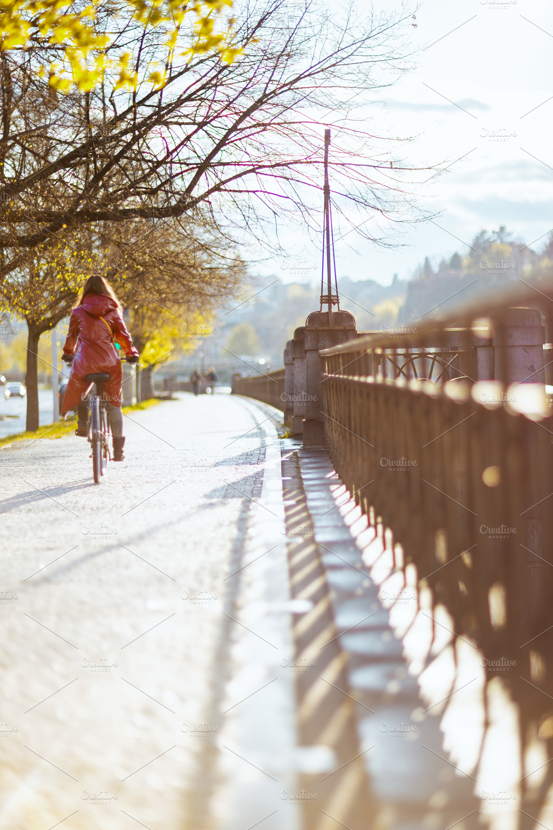 female in red rain coat outdoors in city riding bicycle, a Person Photo by Alliance Images