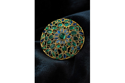 Ornate gold brooch with green and, a Background Photo by Lermont51