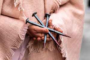 Woman holding nails of Jesus Christ crucifixion in her hands, a Holiday Photo by Antonio Gravante Market