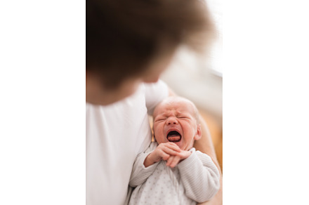 Father holding his crying newborn, a Person Photo by HalfPoint