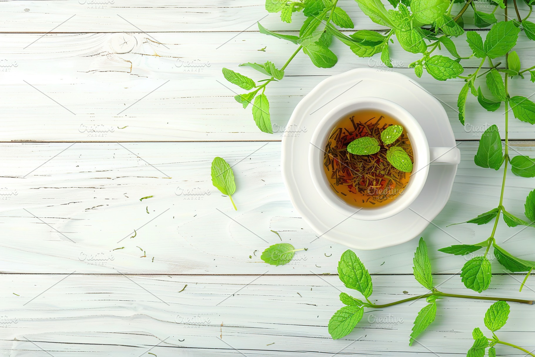 Top view of cup of aromatic tea and green mint leafs on wooden background, a Food & Drink Photo by AlyaAnd