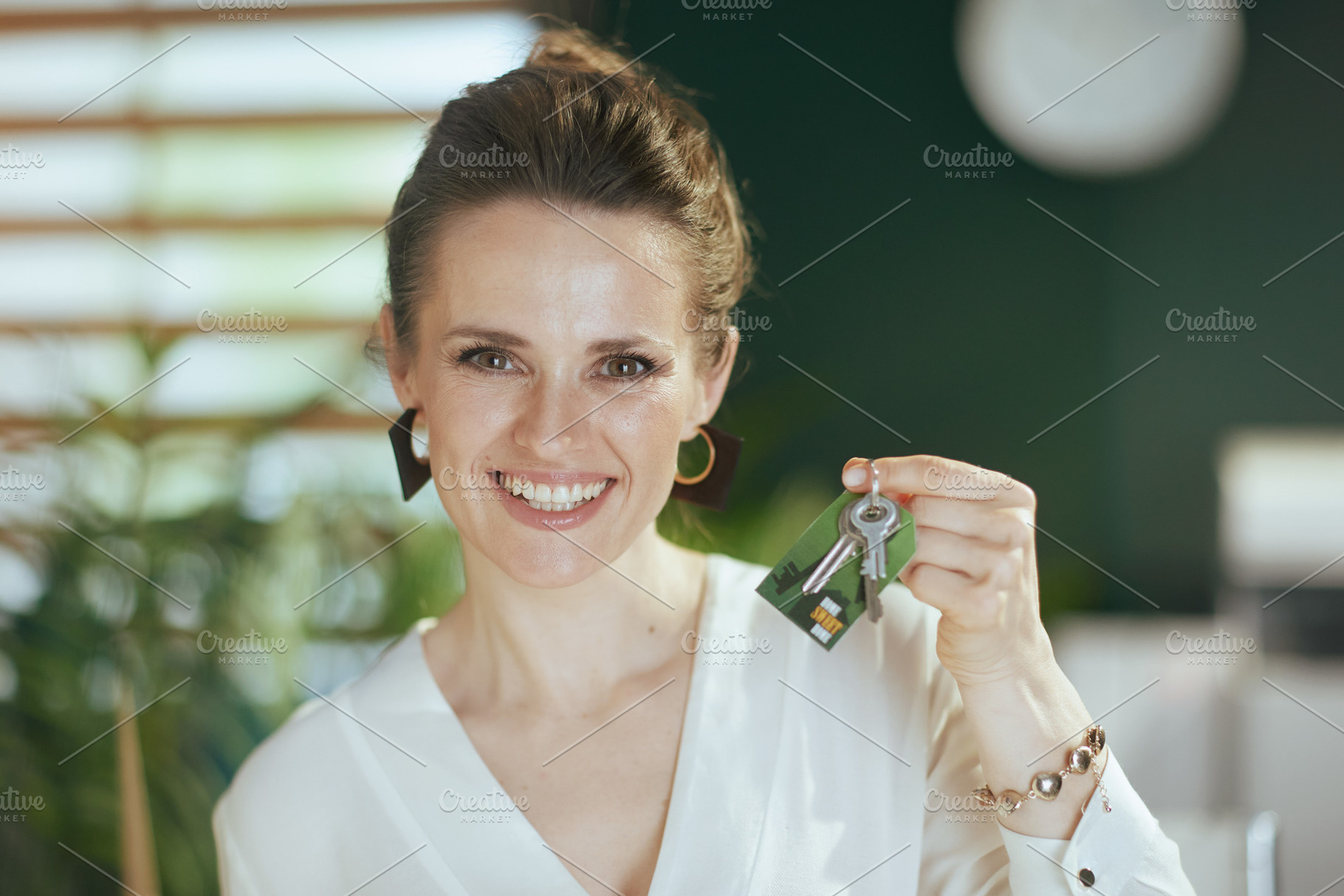 Portrait of smiling stylish female realtor in green office, a Business Photo by Alliance Images