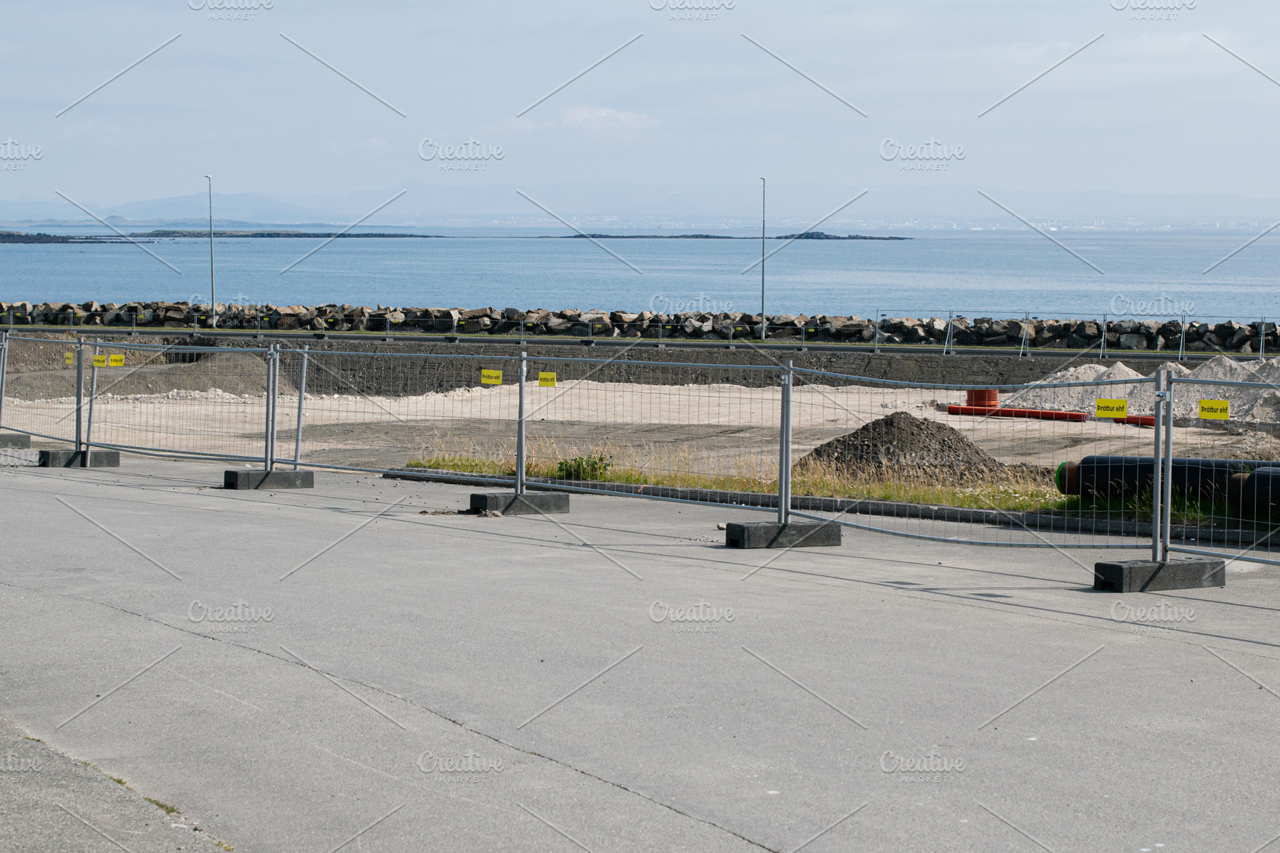 Coastal construction site with barriers and a scenic ocean view in Akranes, a Photo by AS photostudio