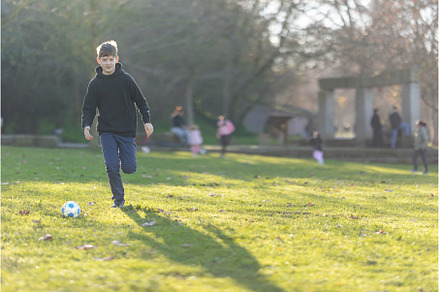 A boy is playing soccer in a park, a Sports & Recreation Photo by Barcelona_dreams