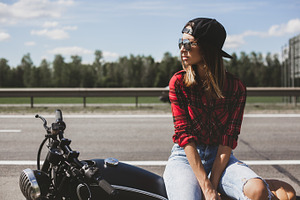 Biker girl sitting on motorcycle featuring woman, fashion, and retro, a Person Photo by Aliaksei Kaponia