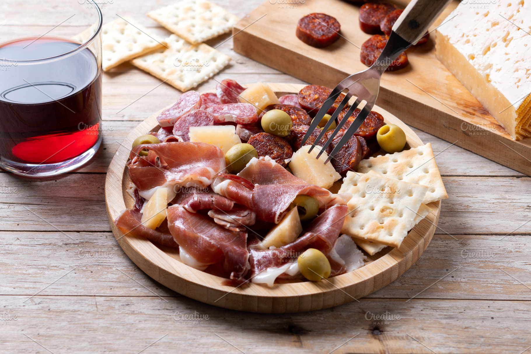 Fork picking up cheese from Spanish charcuterie board, a Food & Drink Photo by etorres69