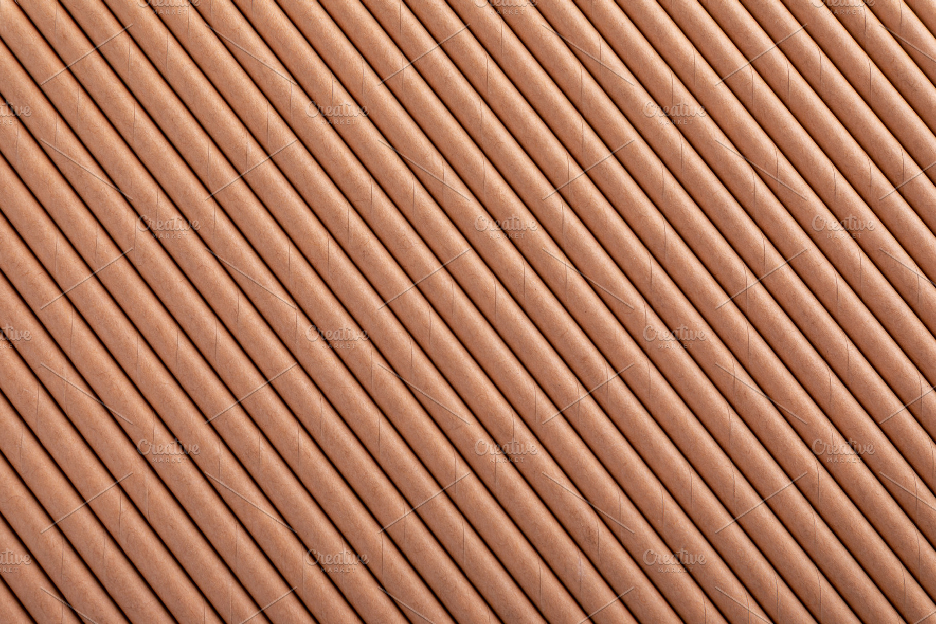 Top view of brown eco paper straws arranged in a diagonal patter, a Background Photo by Ales Munt