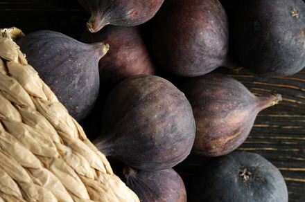 Wicker pot with fig on rustic wooden background, a Food & Drink Photo by AtlasStudio PRO