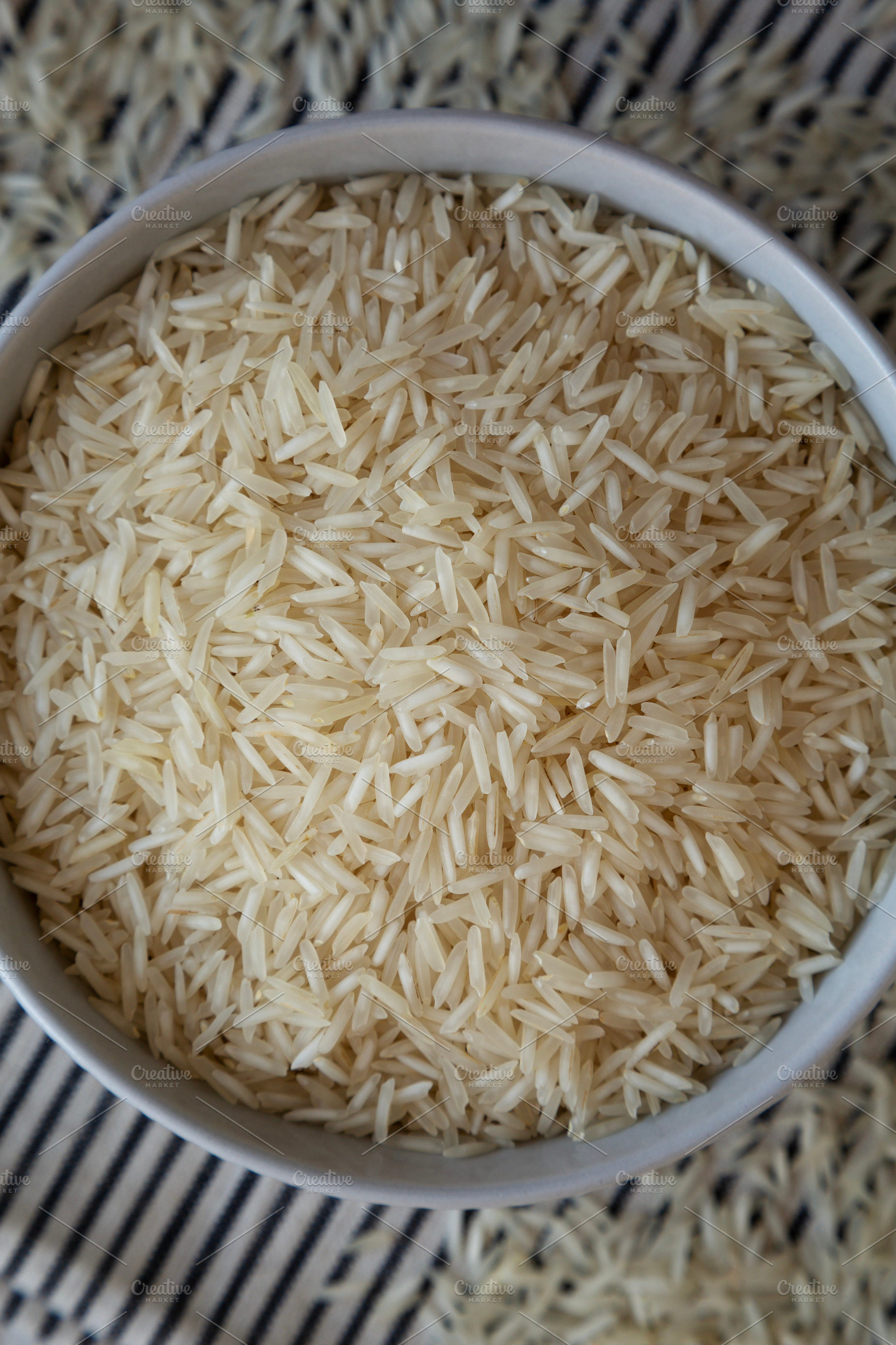 Uncooked White Organic Basmati Rice in a Bowl, top view. Close-u, a Food & Drink Photo by LiudmylaChuhunova
