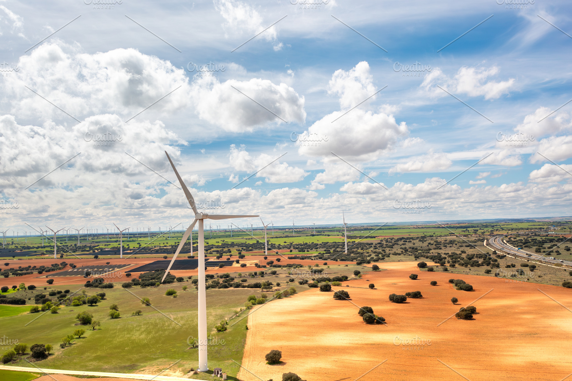 Wind turbines spanning across vast rural landscape under bright sky, a Photo by andreonegin market