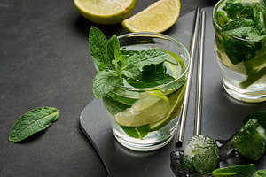 Glass of mojito cocktail with fresh mint leaves, lime slices, an, a Food & Drink Photo by ndanko