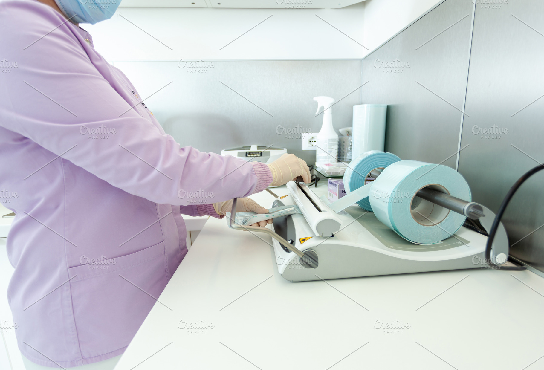 Nurse packing medical instruments using a sealing machine in clinic, a Health & Medical Photo by Antonio Gravante Market