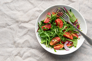 Fresh garden salad with tomatoes, arugula, and onion, a Food & Drink Photo by Olena Rudo