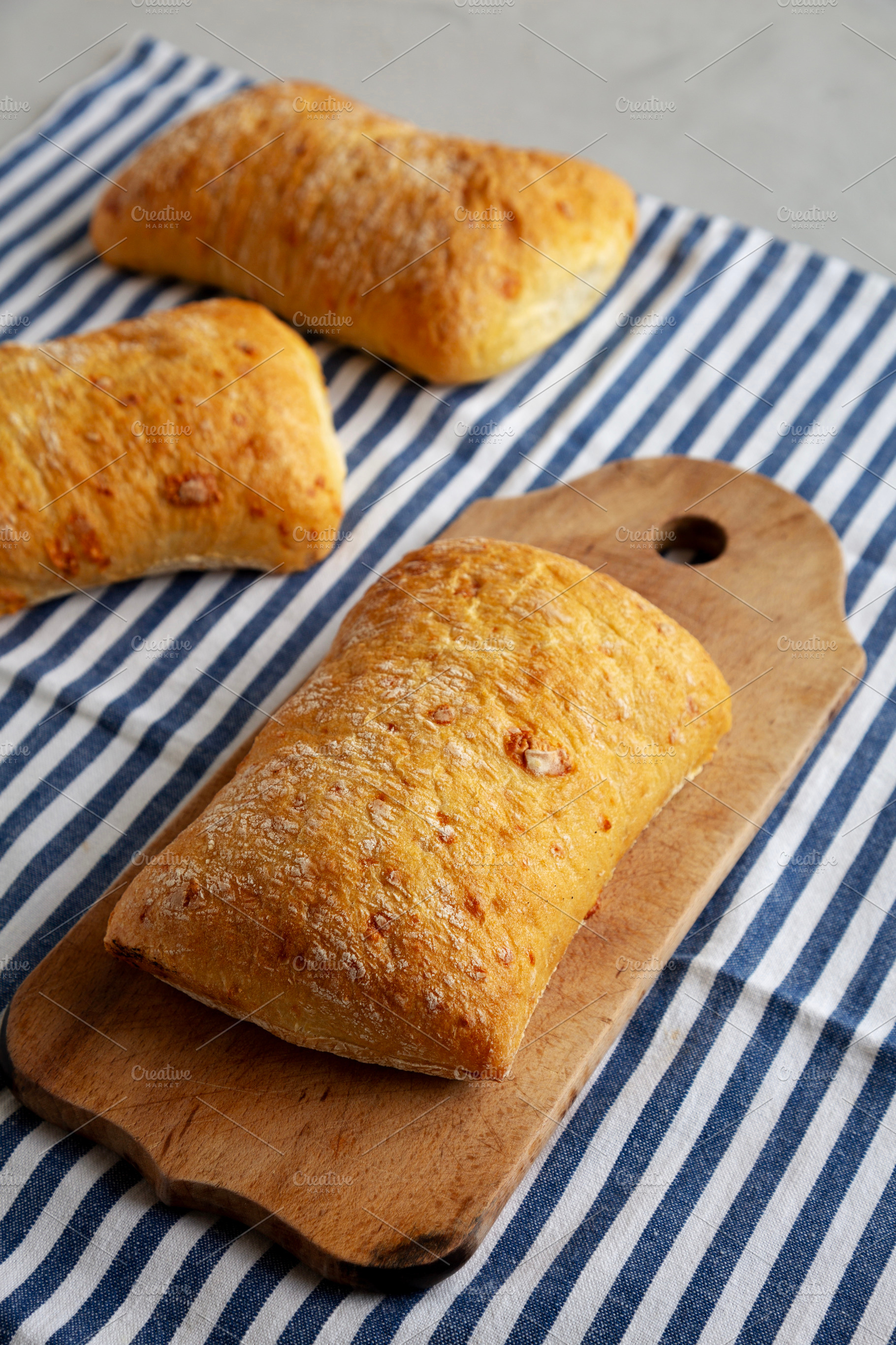 Homemade Cheese Ciabatta Bread on a Wooden Board, side view., a Food & Drink Photo by LiudmylaChuhunova