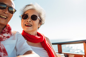 Elderly Asian couple enjoying a relaxing boat ride with smiles,, a Photo by Dvoevnore photos