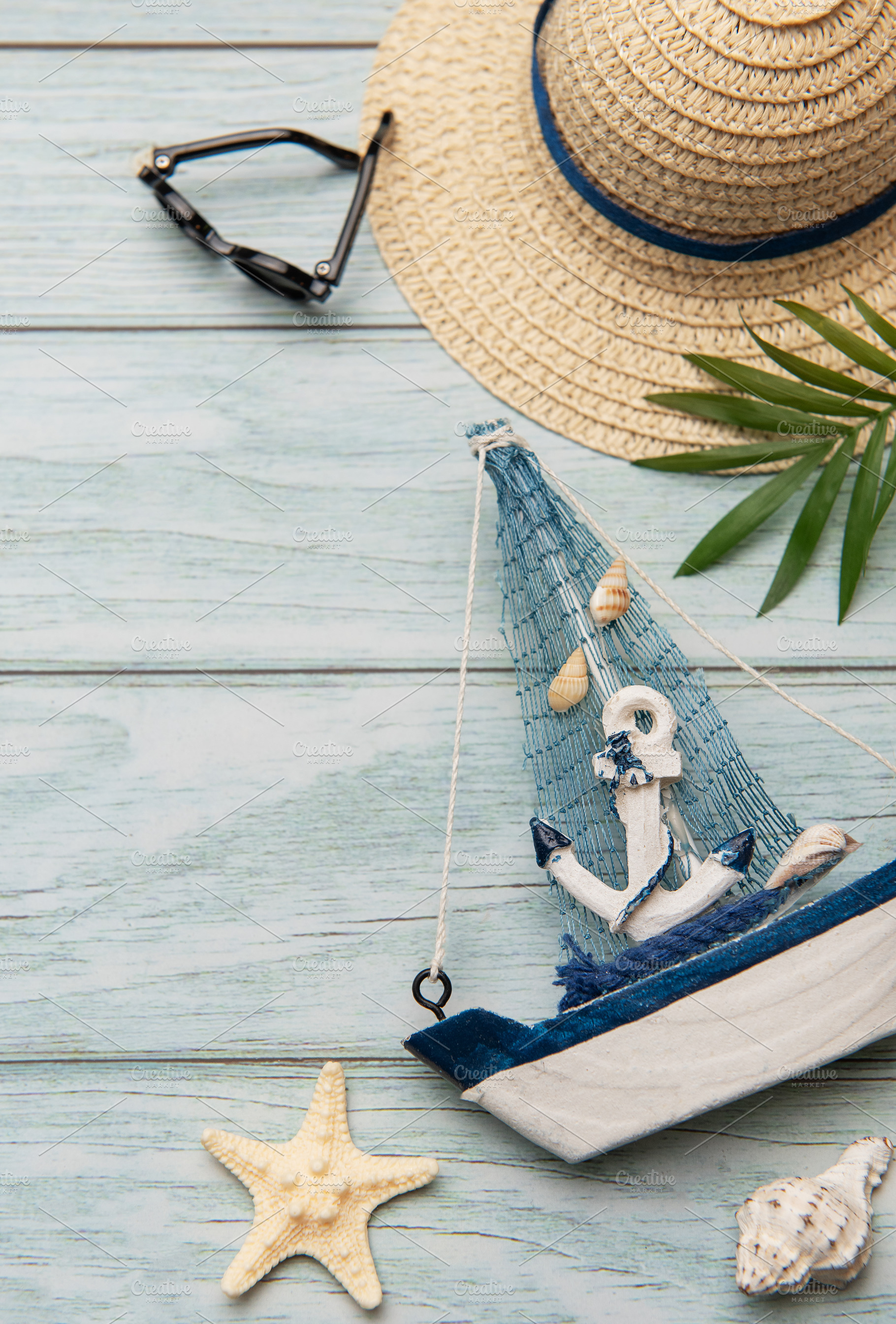 Seashells, sunglasses, straw hat, starfish and decorative sailbo, a Holiday Photo by Olena Rudo