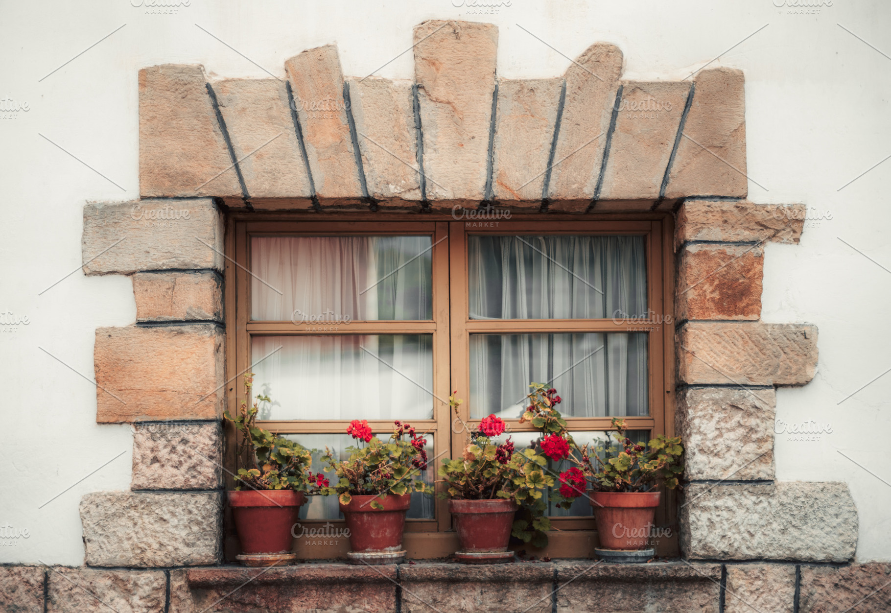 Stone window with red flowers, an Architecture Photo by SkyNext