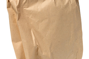 A closed and somewhat crumpled brown paper bag, isolated backgro, a Photo by ndanko