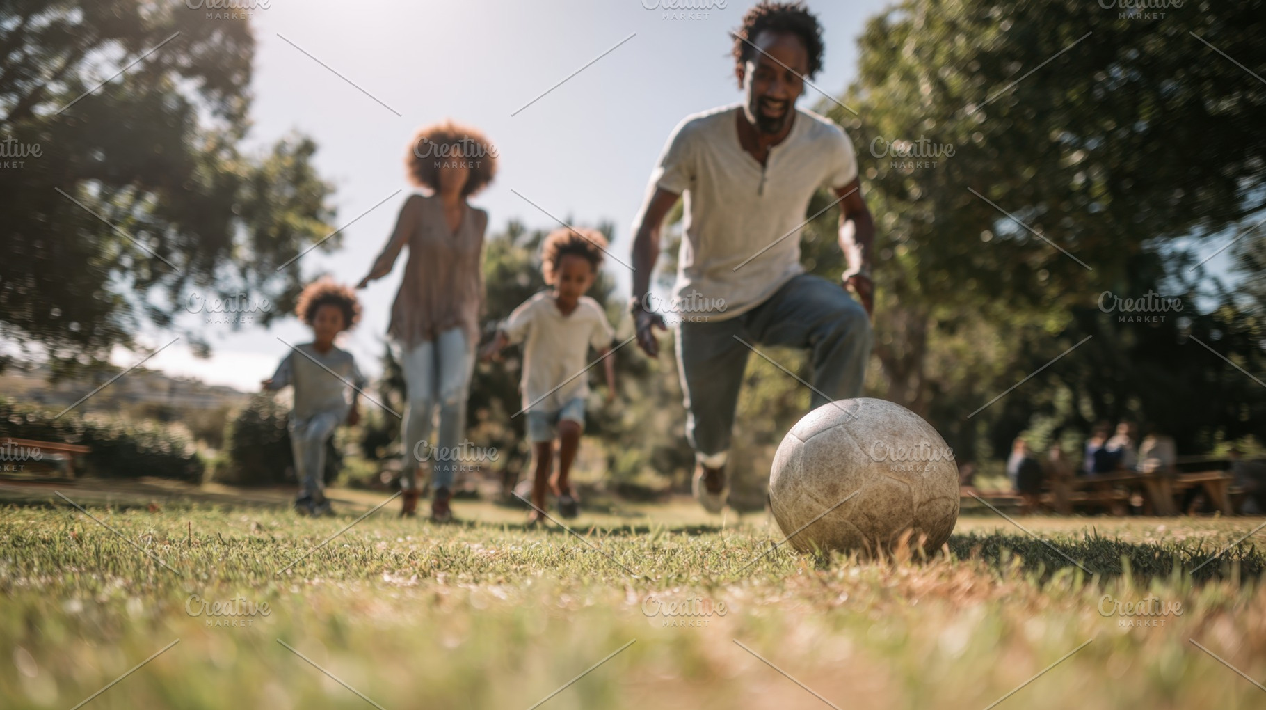 Family plays soccer in the park, a Photo by Beautiful things