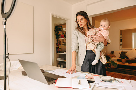 Interior designer holding her baby while working in her home off, a Person Photo by Jacob Lund