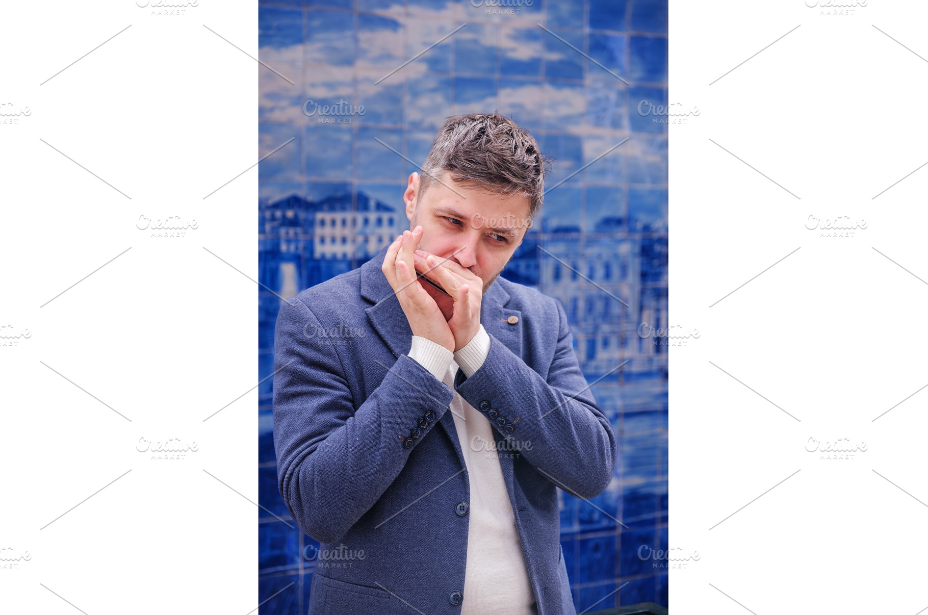 Man plays harmonica outdoors in city, a Person Photo by f9photos