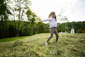 Young girl enjoying nature while playing outdoors in a grassy field, a Person Photo by AS photostudio