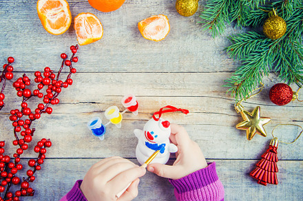 A child paints a Christmas toy, a, a Holiday Photo by yanadjana