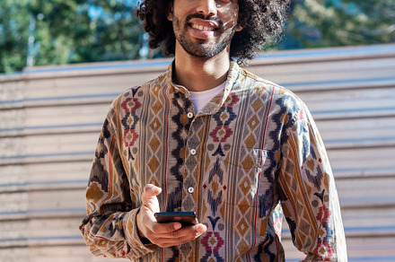 Portrait of handsome afro man using his mobile in the street., a Person Photo by RF Images