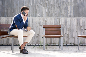 Businessman talking on smartphone outside modern office building, a Photo by etorres69