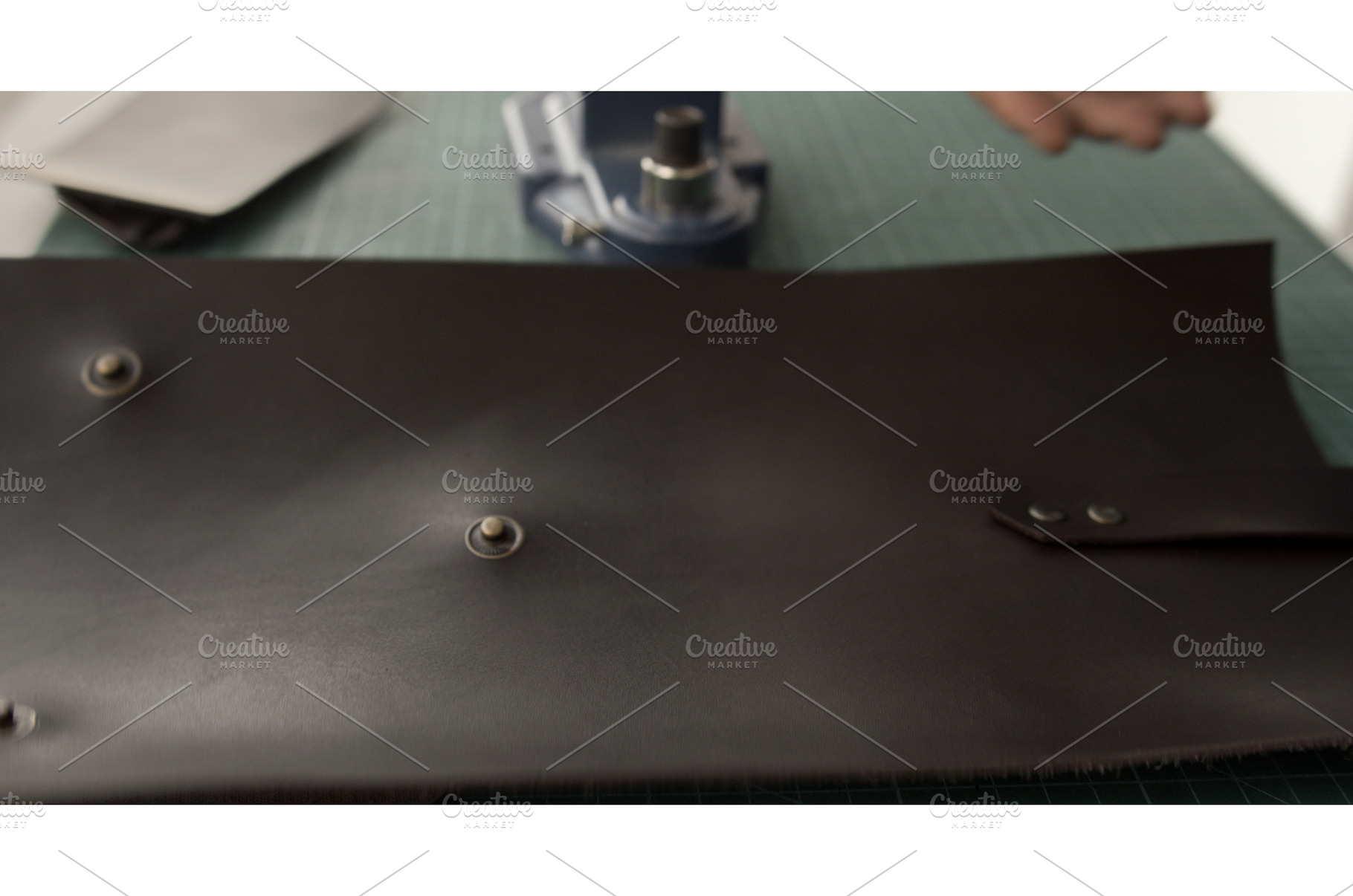 Setting hardware on leather piece, an Industrial Photo by volodymyrshtun13795