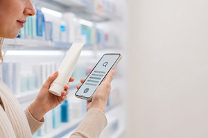 Woman holding sunscreen and smartpho, a Photo by Dvoevnore photos