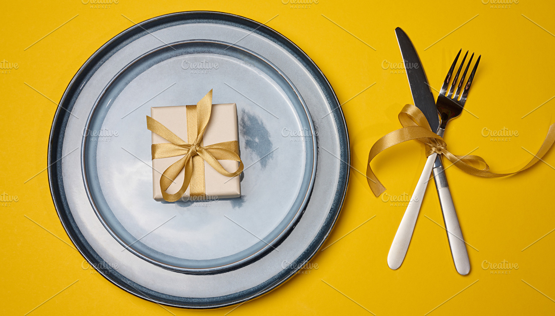 A festive table setting on a yellow background with a gray plate, a Food & Drink Photo by ndanko