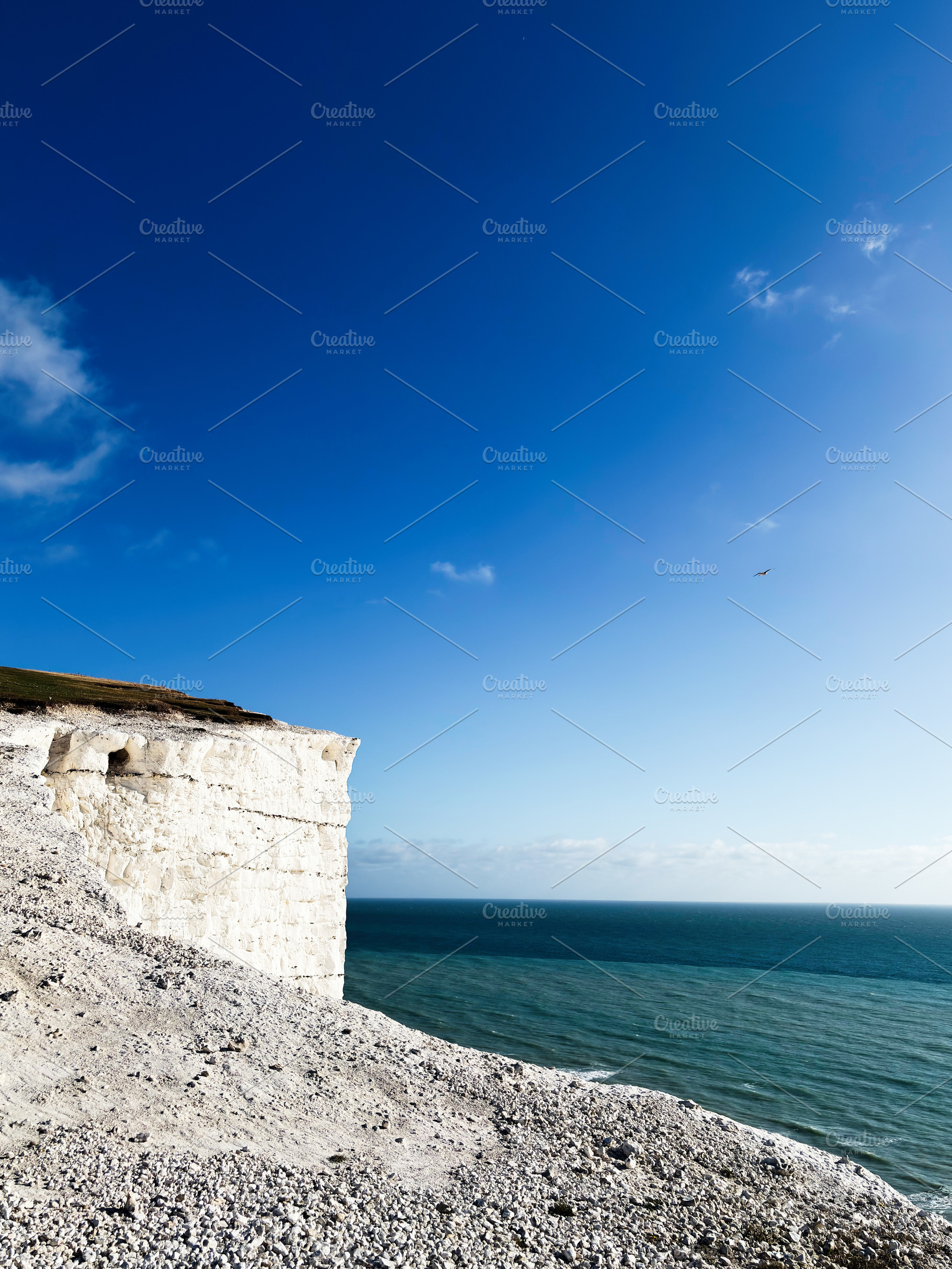 Cliffs at Seven Sisters in East Sussex overlook the sea under a clear blue sky, a Nature Photo by AS photostudio