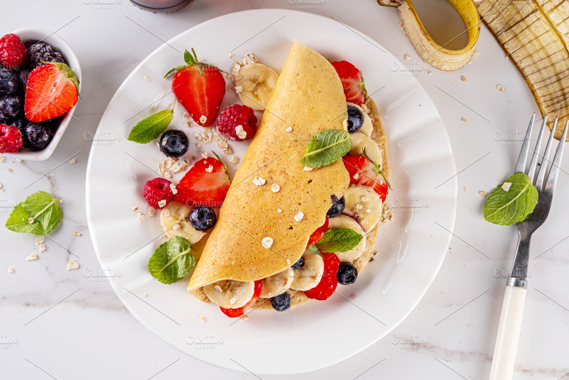 Tasty stuffed oatmeal banana pancake with fresh fruits and berri, a Food & Drink Photo by Rimma