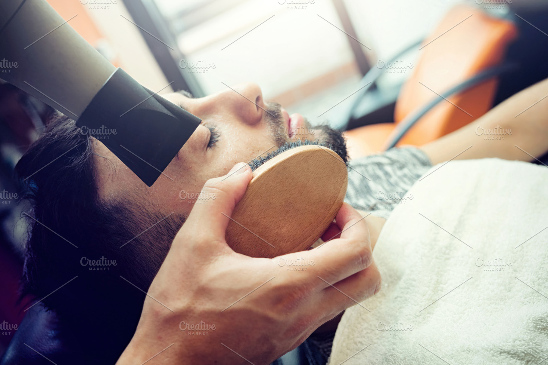 Professional barber styling client's beard with hairdryer and brush, working at, a Person Photo by Antonio Gravante Market