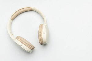 Modern wireless headphones lying on white background, a Business Photo by Olena Rudo