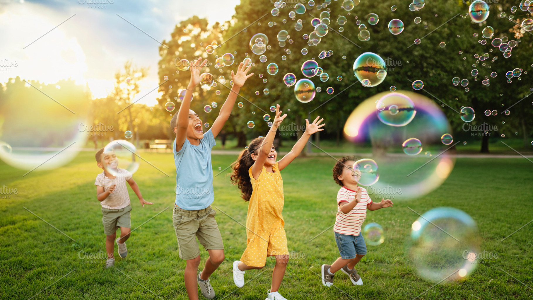 Happy children chasing and popping soap bubbles in a grassy park, a Person Photo by DanFLCreativo