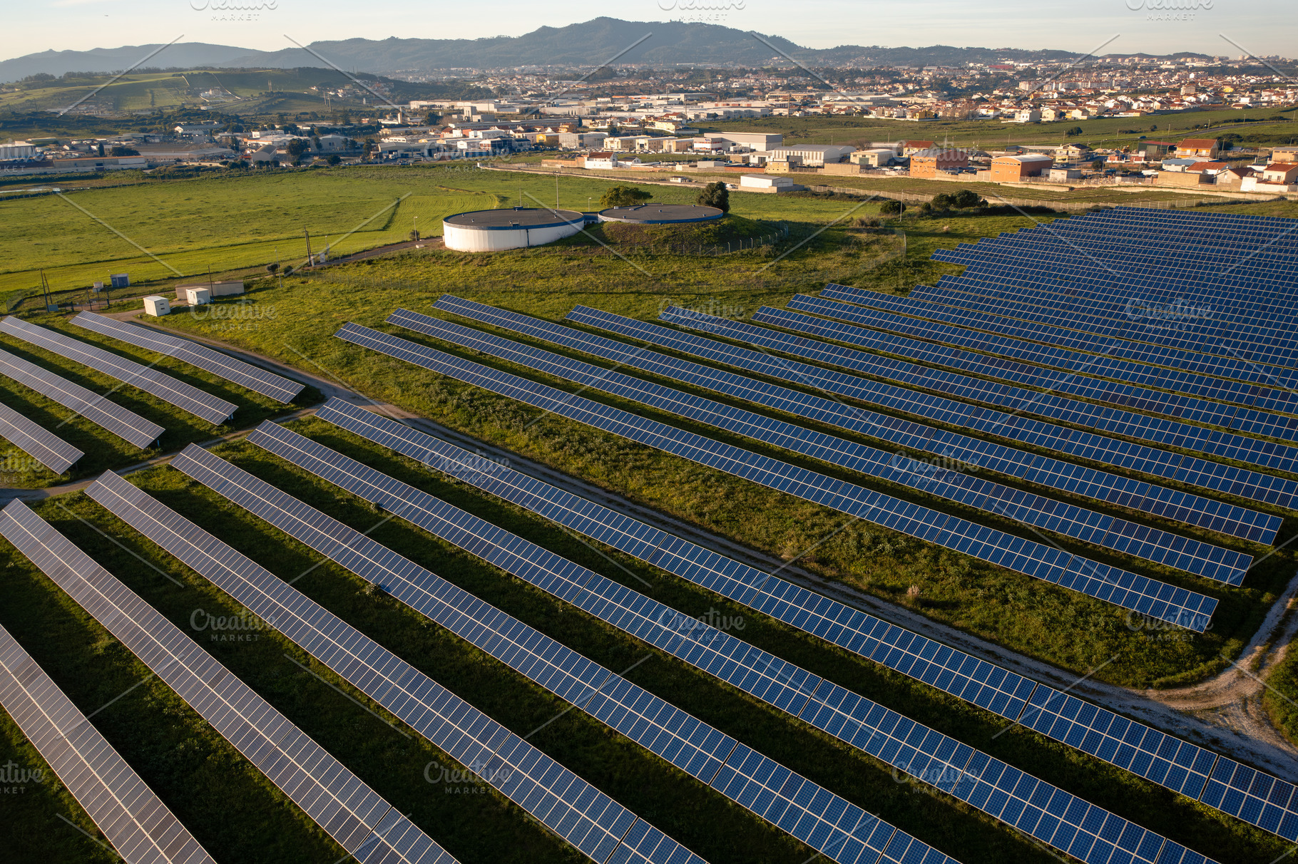 Solar panel farm located in a rural area with rolling hills and small towns nea, a Photo by andreonegin market