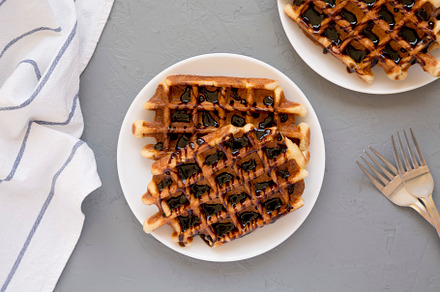 Yummy Homemade Belgian Sugar Waffles on a white plate on a gray, a Food & Drink Photo by LiudmylaChuhunova