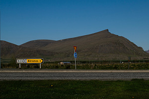Countryside landscape near Akranes Iceland with road sign and prominent mountai, a Photo by AS photostudio