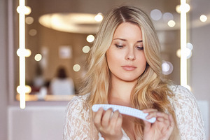 Blonde woman shaping nails with a file, doing manicure and self, a Person Photo by Studio ANNA