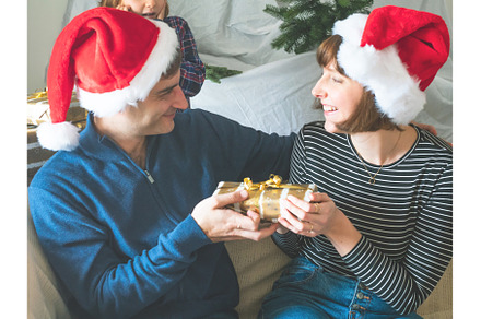 Husband and wife exchanging gifts in, a Holiday Photo by Lifemorning