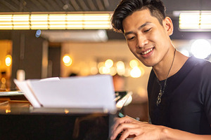Adult pianist performing at the piano in a small bar, a Person Photo by DanFLCreativo