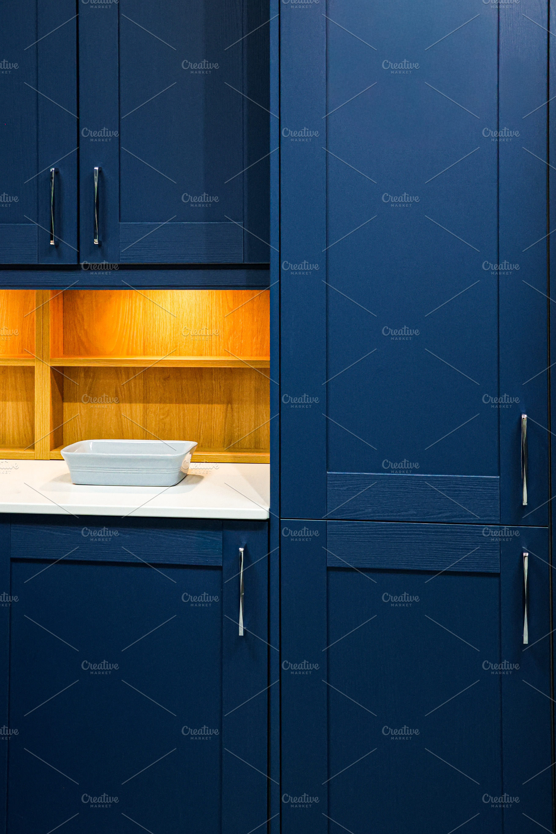 Blue kitchen cabinets featuring integrated storage solutions, wood shelves with, a Photo by Studio ANNA