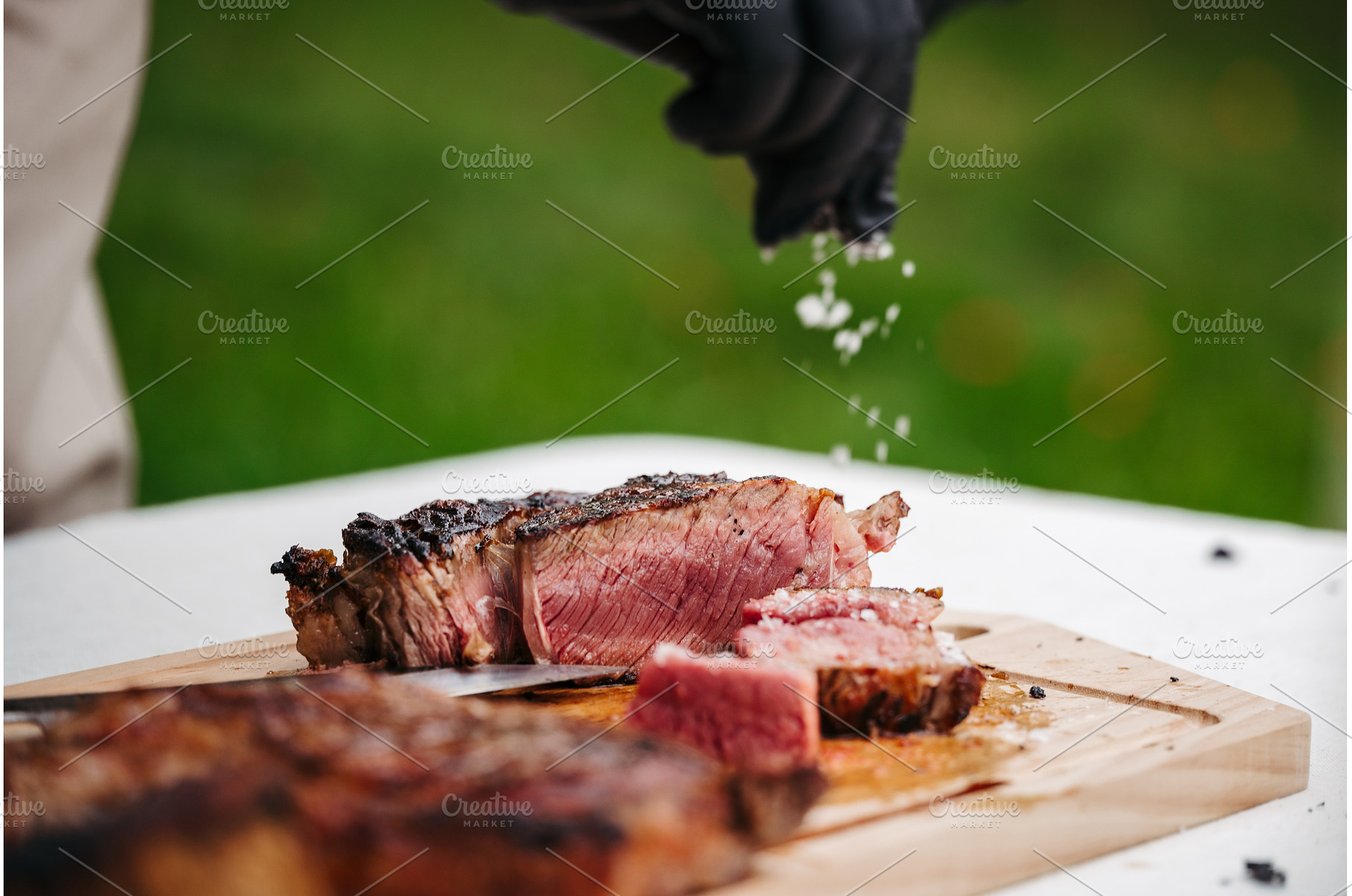 Chef salting juicy grilled steak on, a Food & Drink Photo by HalfPoint