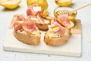 Close up of Italian bruschetta a slice of crusty bread with pros, a Food & Drink Photo by ndanko