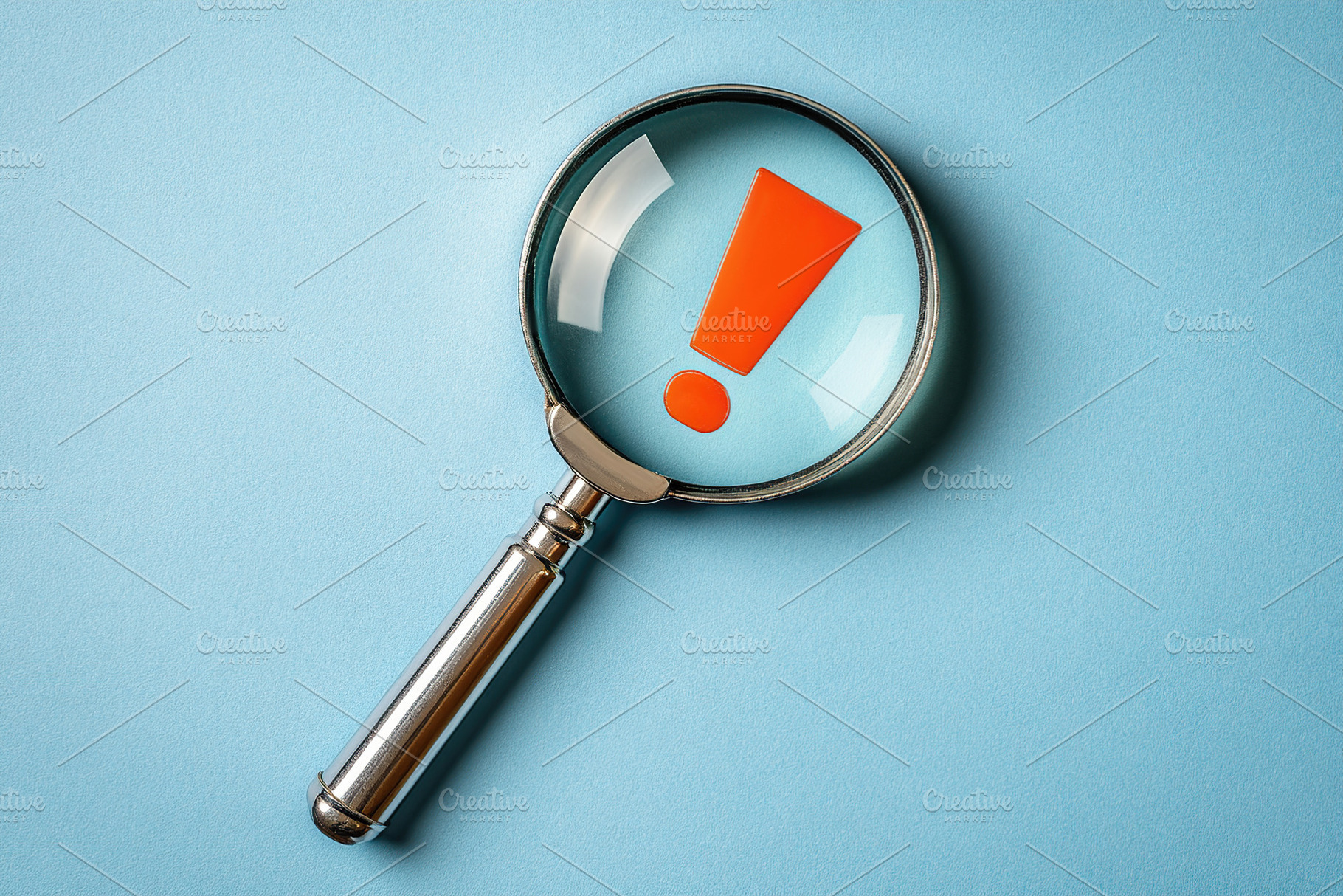 Magnifying glass shows a red exclamation mark on a light blue minimalistic back, an Abstract Photo by AlyaAnd
