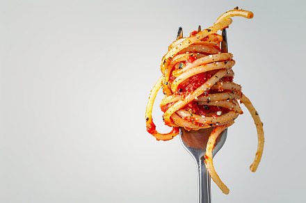 Spaghetti rolled on a fork on white background, a Food & Drink Photo by AlyaAnd