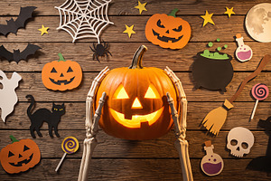skeleton holding Halloween pumpkin