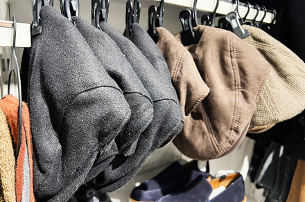 A collection of stylish hats displayed on hooks with shoes nearby, a Photo by AS photostudio